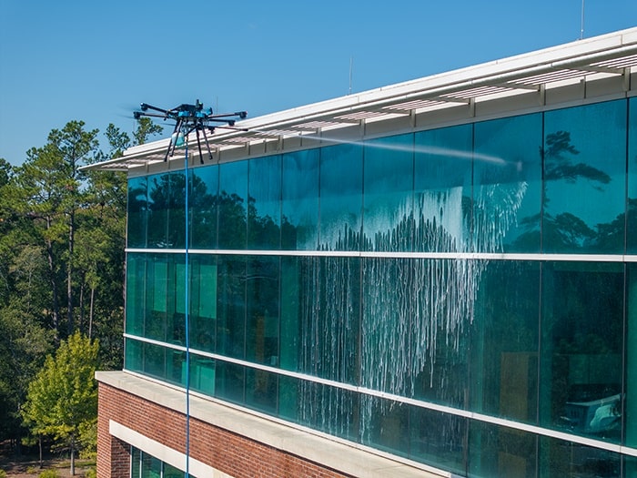Drone window cleaning service in NYC showing a drone cleaning skyscraper windows